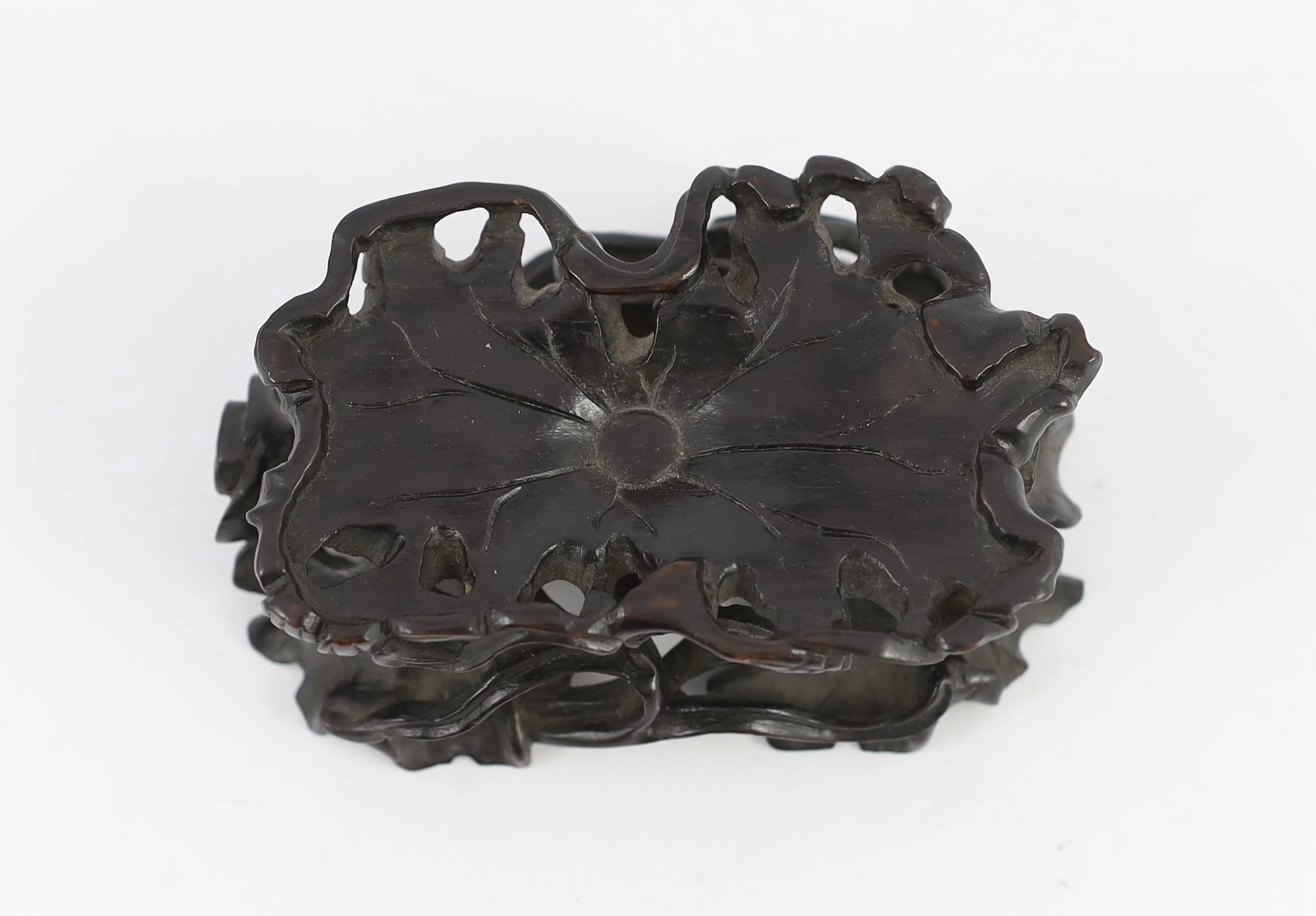 A Chinese carved wood ‘lotus’ stand and a Chinese huanghuali ‘dragon’ stand, Qing dynasty